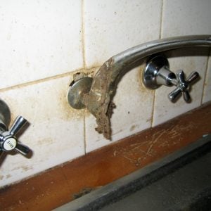 examples of failure of health hardware in wet areas. Build up from leaking tap and hard water. Cracked tile behind spout can cause major issues if wall cavity gets wet.